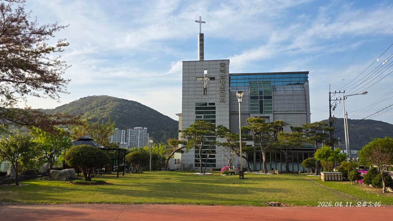 산을 배경으로 한 교회 본당 외관